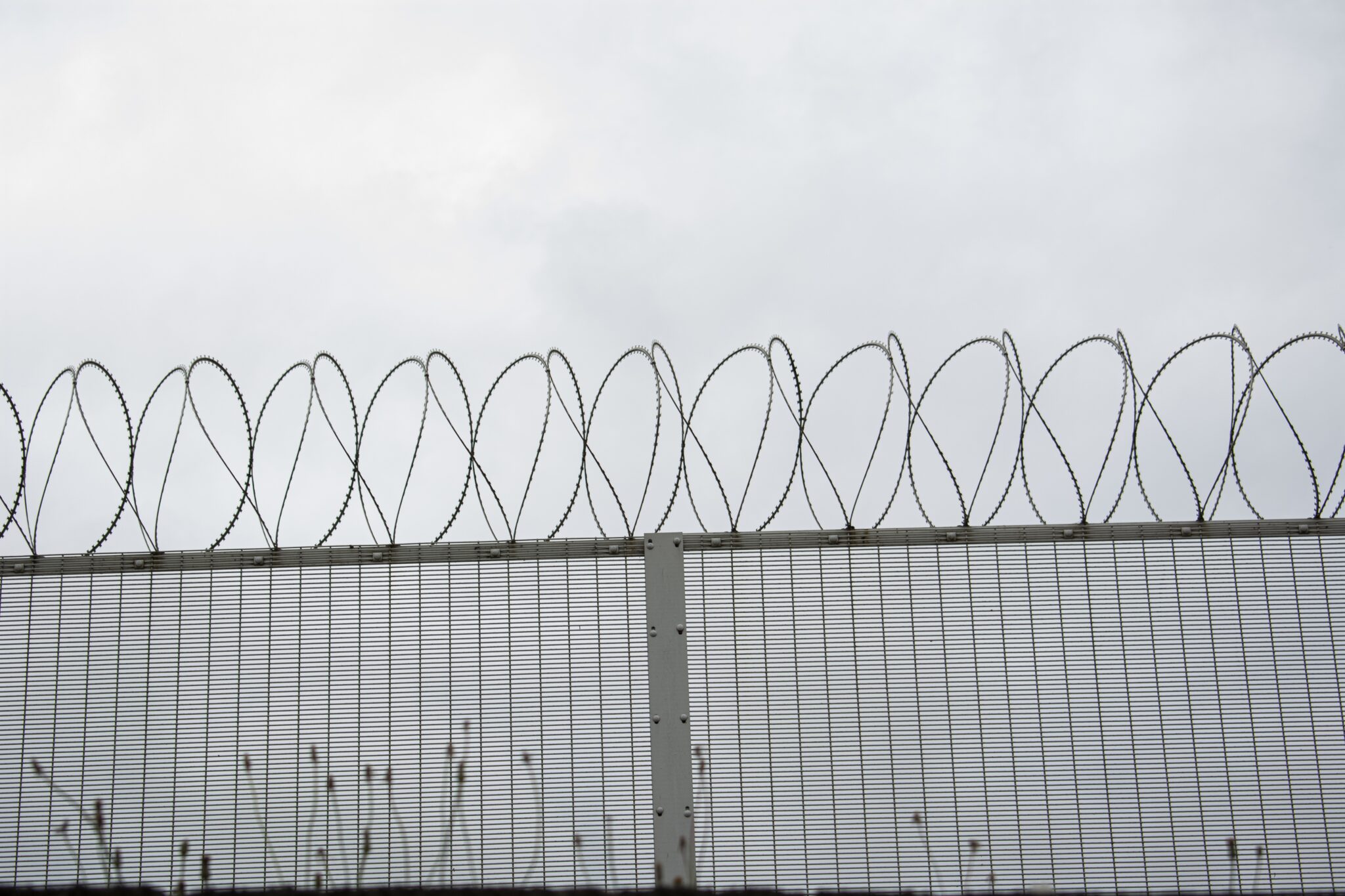 background of a fence with barbed wires under a dark sky